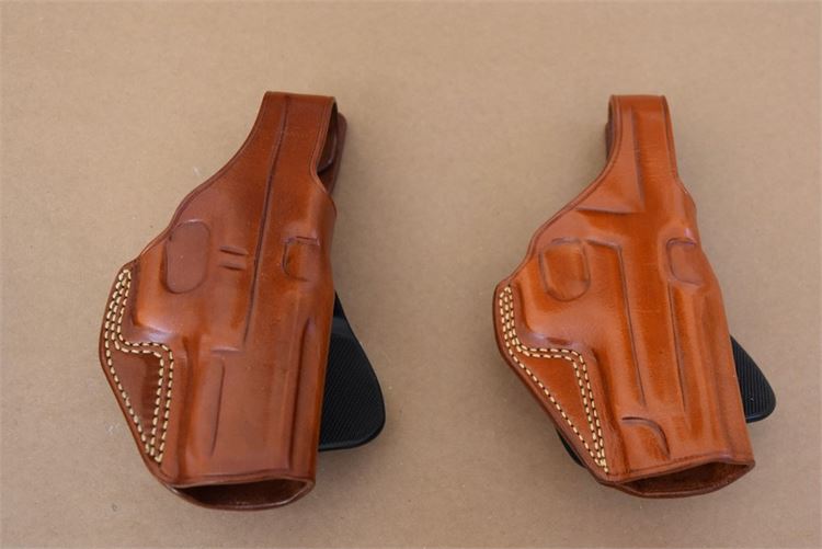 2 Galco paddle holsters, stained leather, one for a Glock, one for a Sig.
